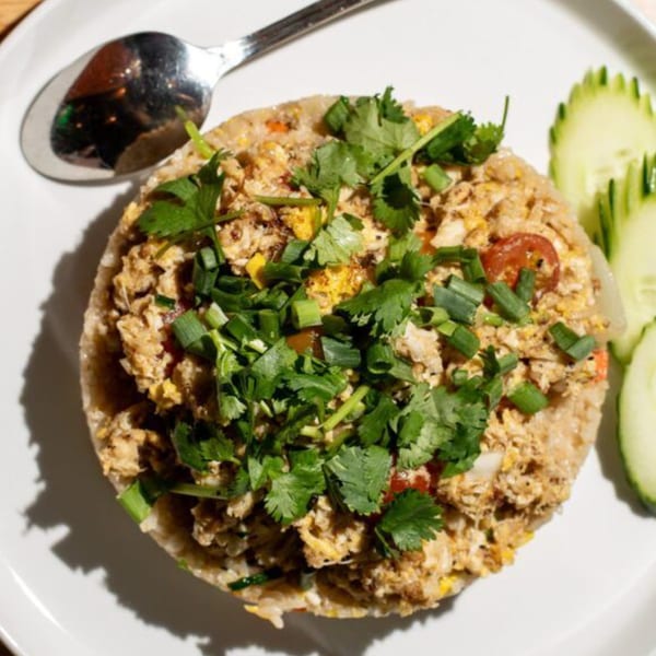 Kin Dee Thai's crab fried rice, garnished with cilantro and scallions, served with cucumber slices.
