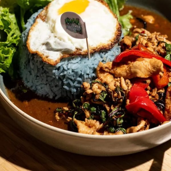 Kin Dee Thai's blue rice with fried egg, chicken, red peppers, and basil in a brown sauce.